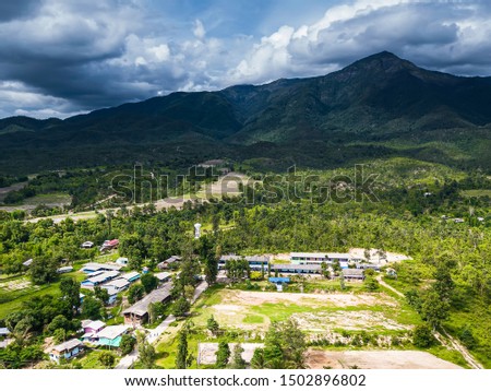 Aerial view Shot by Drone Village Small among mountains, forests, rice fields, rivers