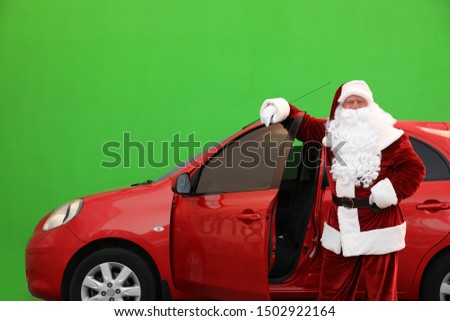 Authentic Santa Claus near car against green background