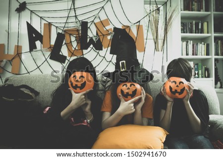Group of girl and boy kids dress up costume and hold the pumpkin bowl at face for trick or treat for Halloween day theme coming soon together