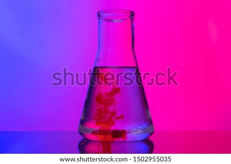Laboratory glass tubes with chemicals on bright pink background