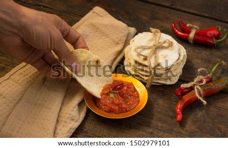 Harissa male hand pita bread rustic wooden table