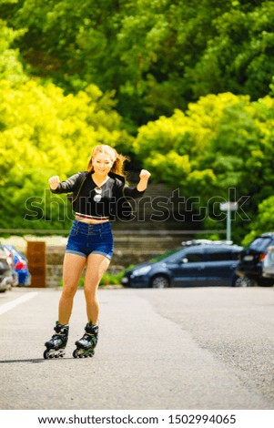 Teenage woman girl riding roller skates during summertime through city having great  time, blur