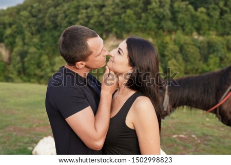 Beautiful couple with a horse in the mountains