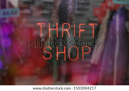 Vintage Neon Thrift Shop Sign in Wet Window