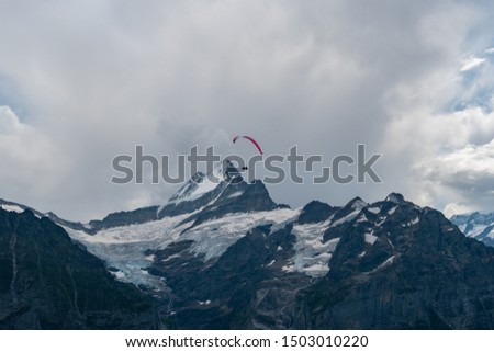 view over the mountains in Grindelwald with a Paraglider in the Picture