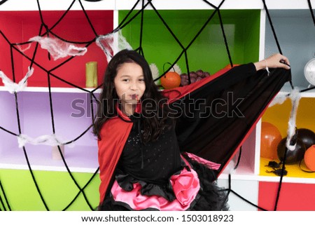girl kids smiling and dress up as Halloween vampire costume and knock on door for trick or treat for Halloween day theme coming soon