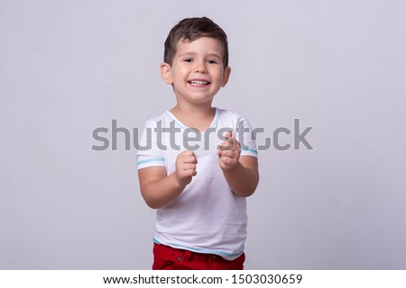 Cute kid holding discount white card in  hand. Kid with credit card. Little boy showing empty blank paper note copy space.