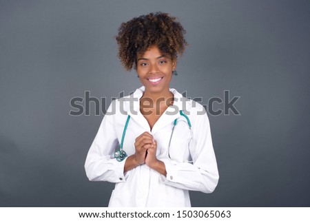 Wow. Beautiful doctor  African American  female isolated on gray studio background. Young emotional surprised woman standing with open mouth. Human emotions, facial expression concept.