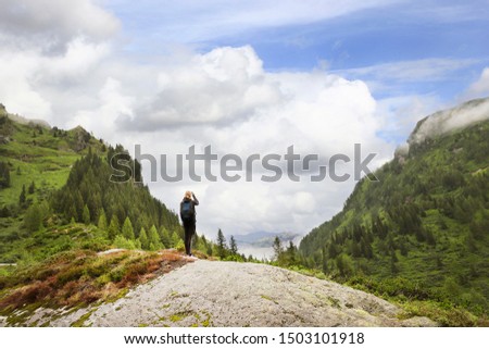 Young girl take picrure on the top of the mountain.