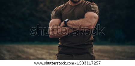 Closeup photo shoot of strong military man in army uniform with watch on his hand is standing crossed his hands.
 Royalty-Free Stock Photo #1503117257