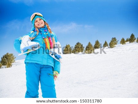 Smiling happy 10 years old Caucasian girl standing with ice-skates outside on winter day