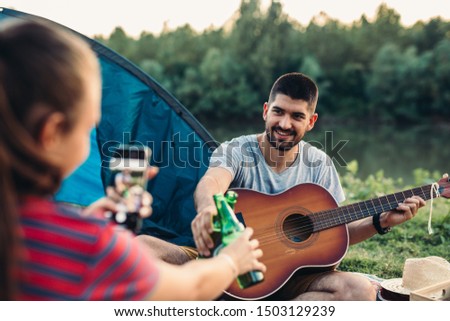 romantic couple on camping together having fun outdoor by the lake