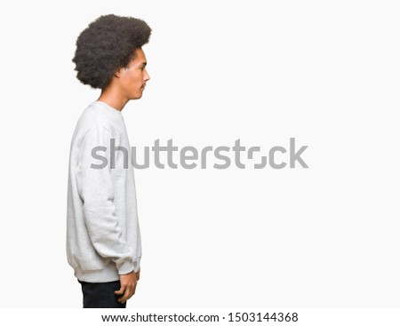 Young african american man with afro hair wearing sporty sweatshirt looking to side, relax profile pose with natural face with confident smile.