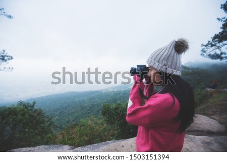 Asian women go hiking on winter,Tourist woman taking with camera travel picture, enjoying mountains landscape,Travel take photo, tourist,Hipster young girl is shooting photo