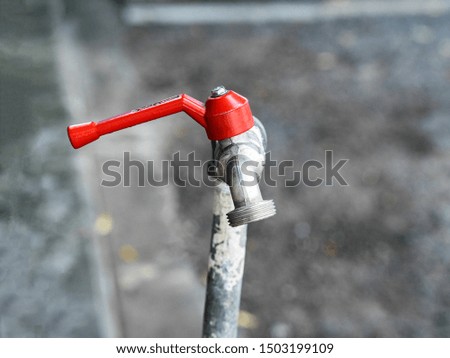 Red water tap blurred background