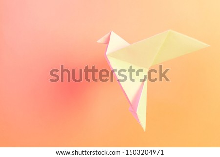 Origami paper white doves on a pastel pink background. The concept of arts and crafts, activities for children. Minimalism, levitation, place for text. Bright trend neon light.