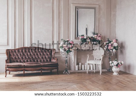 Vintage interior sofa with a vase of flowers in shabby chic style. Royalty-Free Stock Photo #1503223532