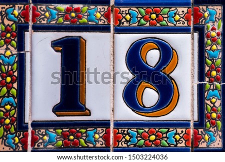Decorative ceramic house number 18 tile on the wall, characteristic decorative element, number