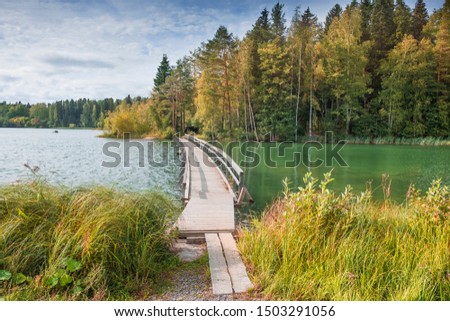 Wooden footbridge to the island on the Vuoksa River in the city of Imatra in Finland. Landscape on a sunny autumn day
