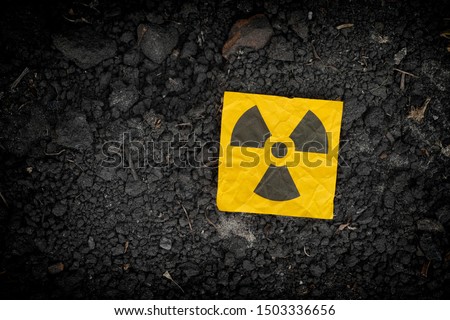 Radiation warning sign on soil background. Close up. Royalty-Free Stock Photo #1503336656