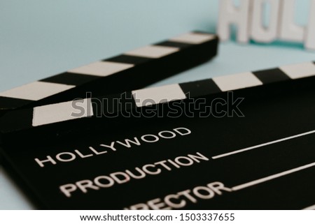 Close-up of a clapboard in a pastel turquoise background. Movie Concept