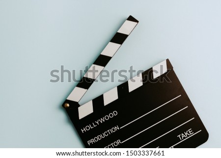 A high view of a Clapboard in a pastel turquoise background. Movie Concept