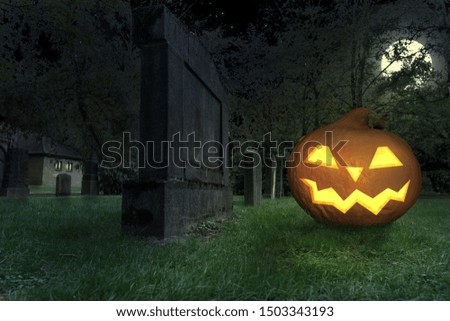 wicked grinning halloween pumpkin lies in a cemetery