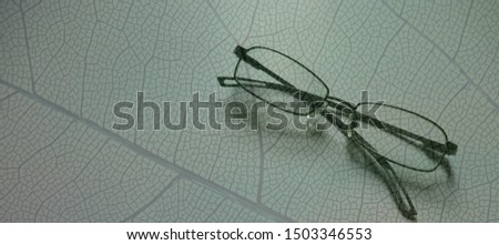 A glasses with green leaf pattern background,banner