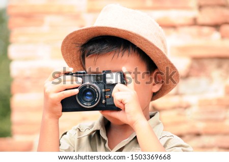 Cute little boy taking a picture with his camera.