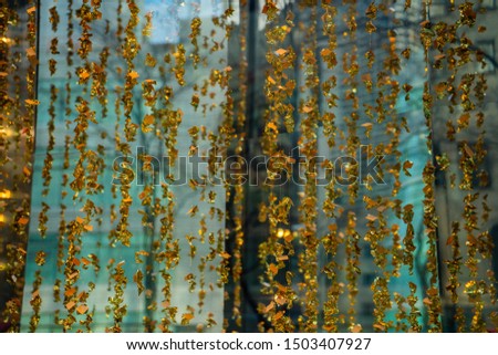 Gold leaf texture in front of a turquoise sea foam green background.