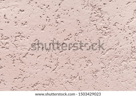 Embossed beige wall trimmed with decorative plaster.
