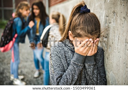 A sad girl intimidation moment on the elementary Age Bullying in Schoolyard Royalty-Free Stock Photo #1503499061
