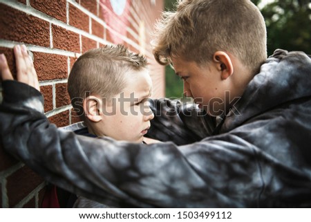 sad intimidation moment Elementary Age Bullying in Schoolyard Royalty-Free Stock Photo #1503499112