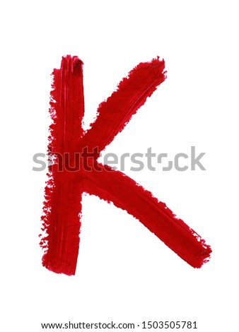 Large letter K of English or Russian alphabet handwritten by dark red color melted lipstick. Roman or Cyrillic  character isolated on white background. Closeup