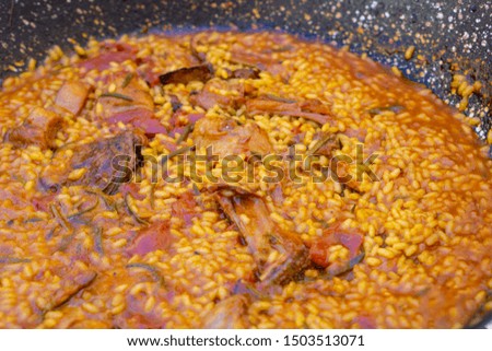 Paella with meat in a wood oven