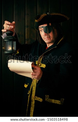 Portrait of a medieval pirate reading a scroll with a lantern in his hand