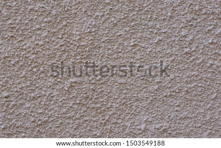 Full frame image of cement or concrete wall painted light beige color. High resolution seamless texture of relief plaster for 3d models, background or collage, copy space