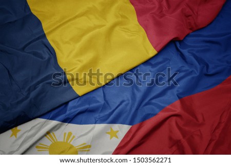 waving colorful flag of philippines and national flag of chad. macro
