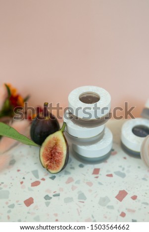 jar of luxury eyeshadow on terrazzo dish, pink background, flower decoration, copy space