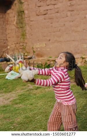 Happy little latin girl playing with toy.