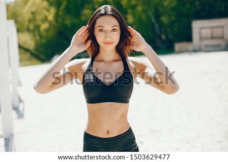 Pretty lady on a summer beach. Sport girl in a black swimsuit