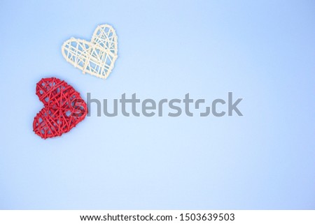 Red and white wooden heart on a blue background. Pattern hearts top view. Valentine's day greeting card. Love concept. Place for text