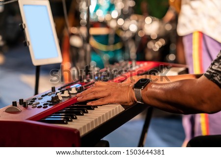 Pianist playing red electric piano in concert at night, music concept.
