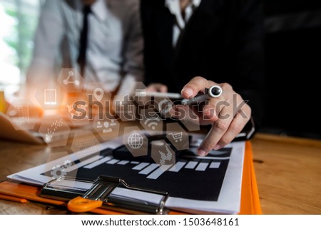 Business teamwork or business partners discussing documents and meeting at the office desk, Smart phone and laptop and two colleagues discussing data in morning light, Calculating or checking balance,