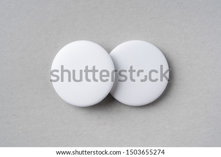 Design concept - top view of 2 white badge on grey background for mockup, it's real photo, not 3D render