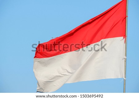 Indonesian flag on the blue sky background.