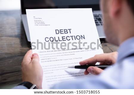Man Reading Debt Collection Notice Letter At Desk Royalty-Free Stock Photo #1503718055