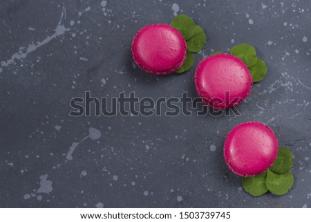 Colorful french macarons cookies(macaroons) on a dark background with copy space. Dessert for served with tea or coffee break. Holiday gift for women.
