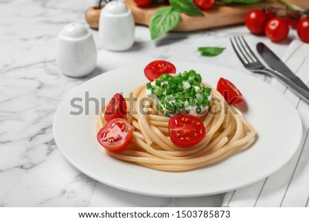 Delicious spaghetti with sour cream dressing on white marble table