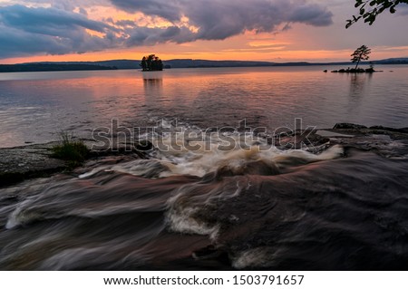 streaming water and colorful sunset over lake